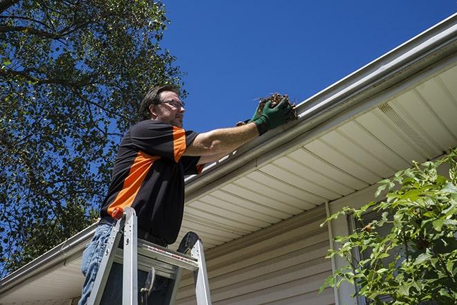 a technician repairing a rusted gutter on a house in Hidden Hills